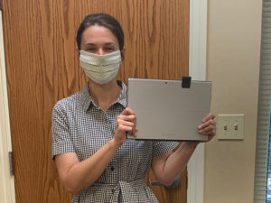 woman wearing mask holding tablet