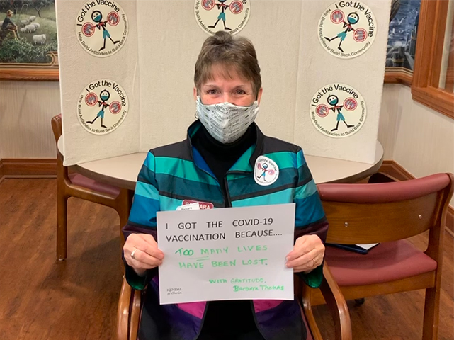 masked woman with poster - Too Many Lives Lost