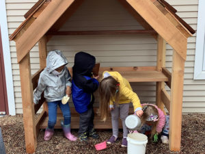 preschool children play in mud kitchen at Kendal