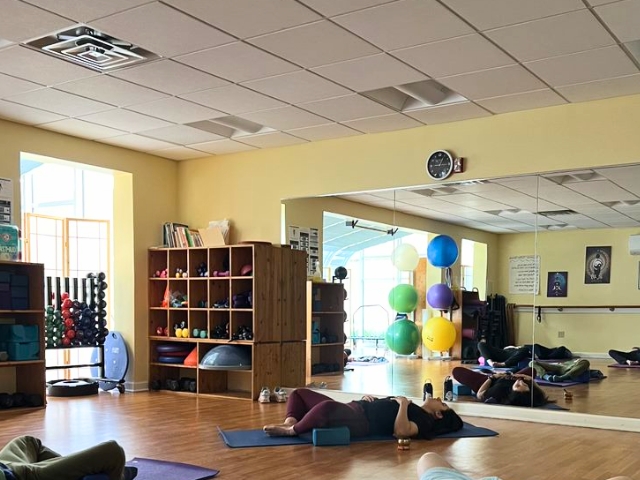 woman doing yoga laying down in group class