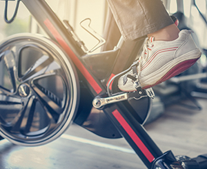 Older adult cycling at the gym to stay healthy 