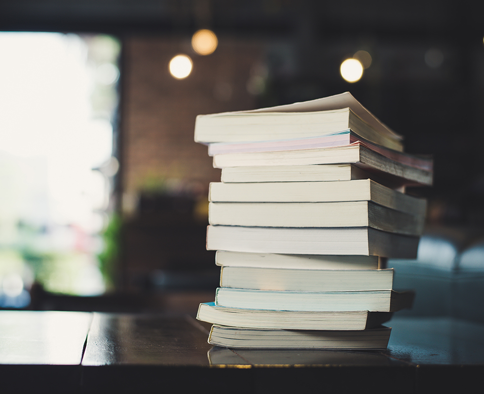 Books stacked on each other on a table in a cafe.