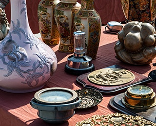 Antiques and memorabilia set out on a table at a garage sale.